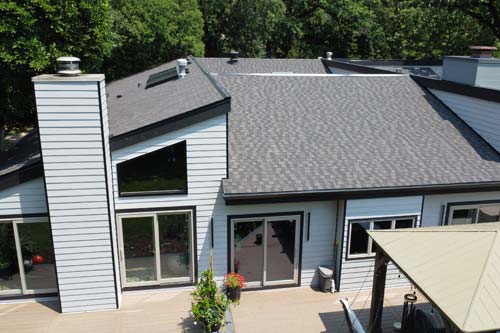 White siding house with black roof. Ariel view.